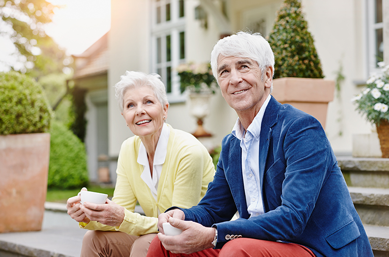 Carefree Gray Haired Senior Woman in Eyeglasses Sitting Relaxed on Home Sofa Looking at Camera Smiling